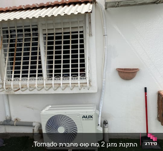 יחידת מזגן חיצונית מותקנת על קיר לבן